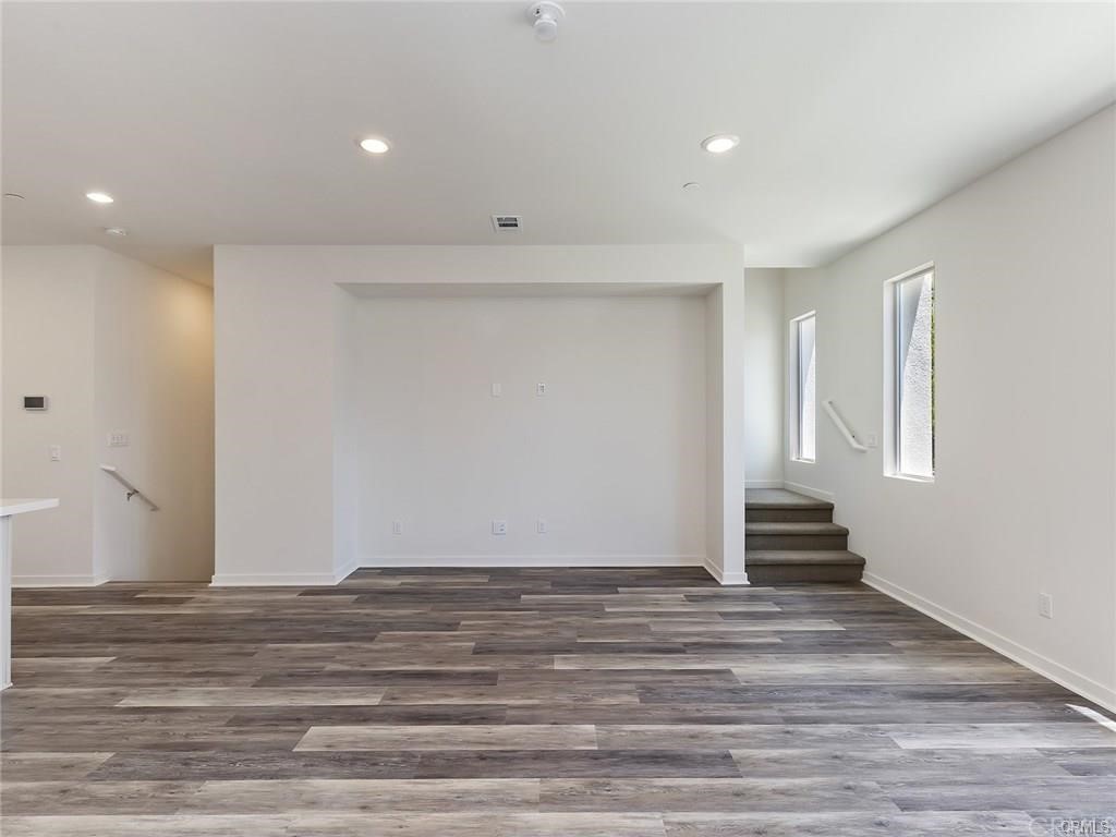 106 Citysquare Irvine, CA 92614 - Photo 6 of 21 a view of an empty room with wooden floor and entryway