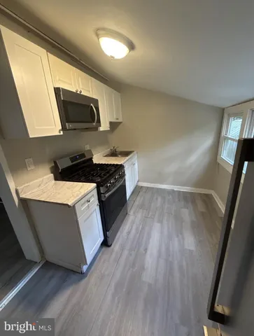a kitchen with wooden floors and a sink