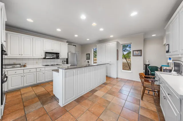 a large white kitchen with cabinets