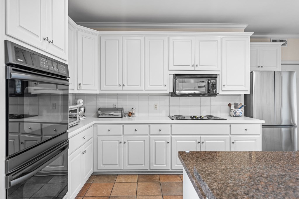 101 Crestline Kerrville, TX 78028 - Photo 12 of 47 a kitchen with granite countertop white cabinets and stainless steel appliances