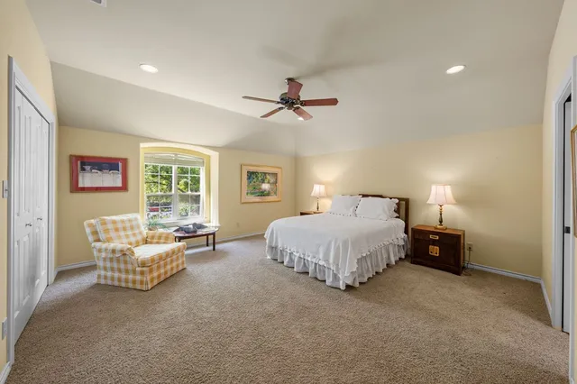a spacious bedroom with a bed and a chandelier