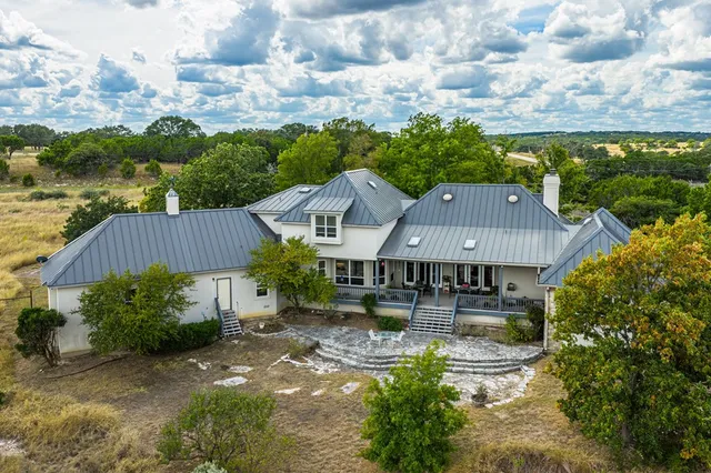 an aerial view of a house with swimming pool patio and lake view