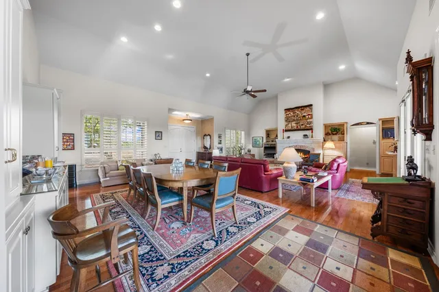a view of a dining room with furniture a rug and wooden floor