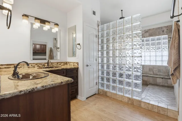 a bathroom with a granite countertop sink a toilet and shower