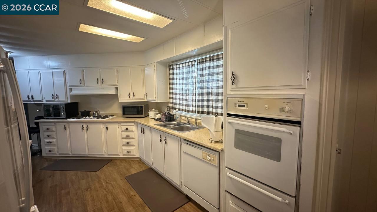 367 Ravine Circle Rancho Cordova, CA 95670 - Photo 12 of 21 a kitchen with a stove white cabinets and a sink