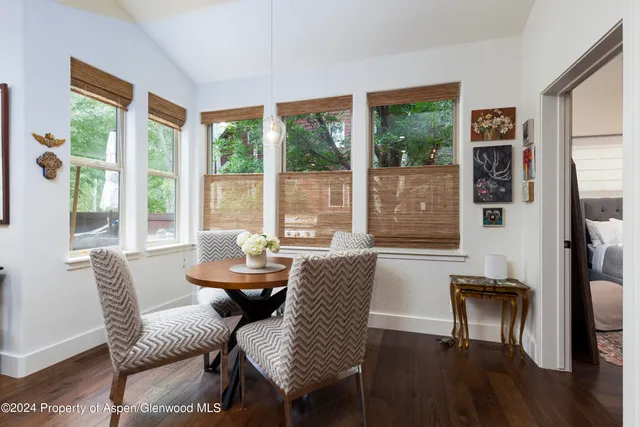 a dining room with furniture and large windows