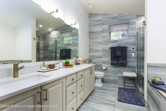 a spacious bathroom with double sink and a large mirror