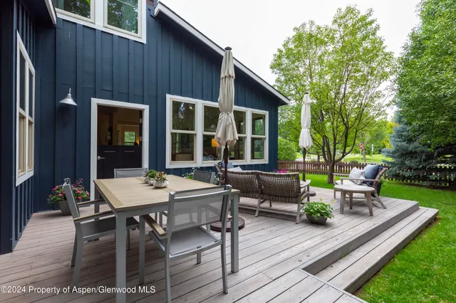 a view of a house with backyard and sitting area