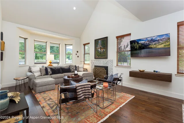a living room with furniture a flat screen tv and a fireplace