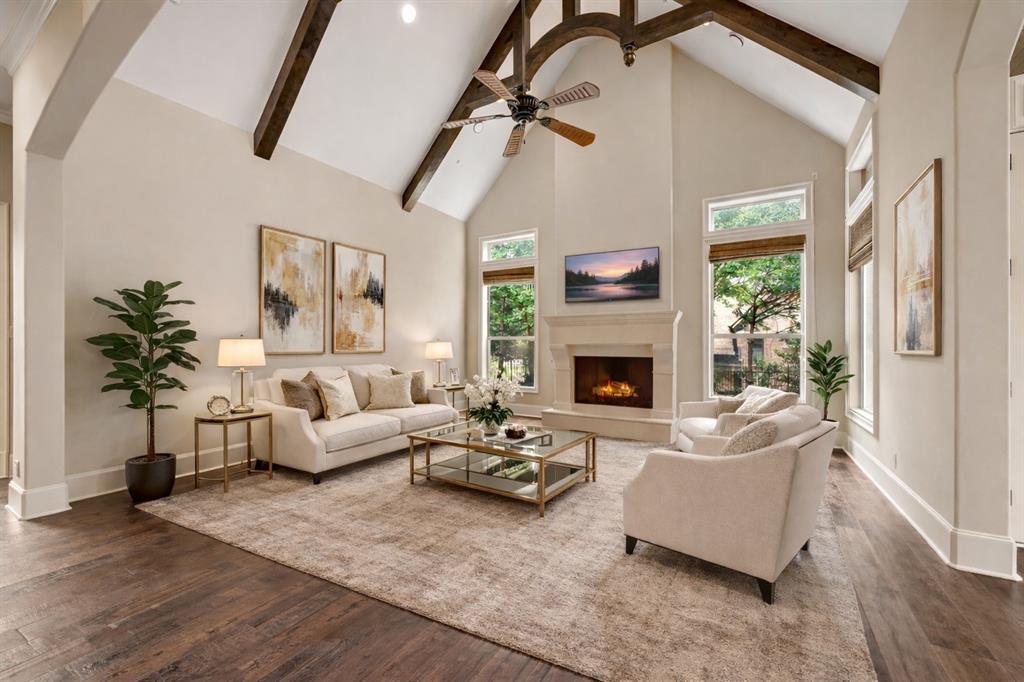 6900 Rockingham Court Colleyville, TX 76034 - Photo 12 of 40 Spacious living area featuring a vaulted ceiling with exposed wood beams, a stone fireplace, and hardwood flooring