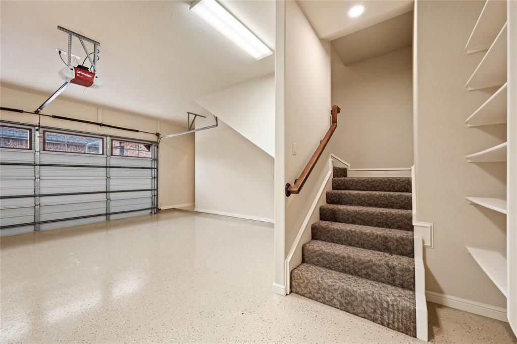 6900 Rockingham Court Colleyville, TX 76034 - Photo 24 of 40 Garage with epoxy flooring, automatic garage door opener, overhead fluorescent lighting, and built-in shelving