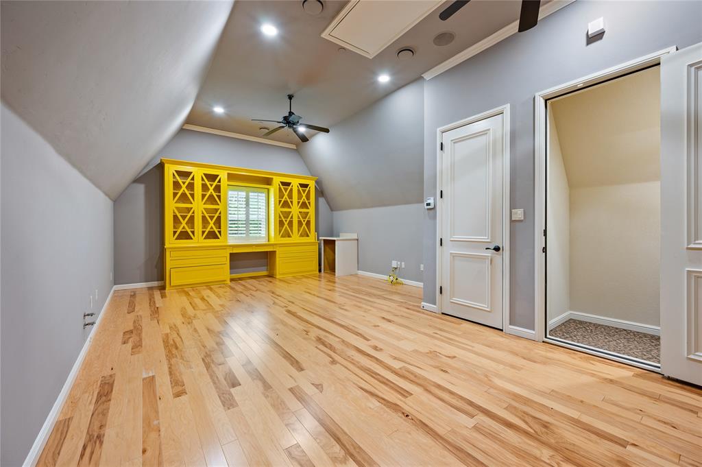 6900 Rockingham Court Colleyville, TX 76034 - Photo 26 of 40 Can be used as a Craft Room, Homeschool Room, or Private Office featuring hardwood flooring, a built-in yellow cabinetry unit with a desk and shelving, a window with plantation shutters, recessed lighting, and a ceiling fan