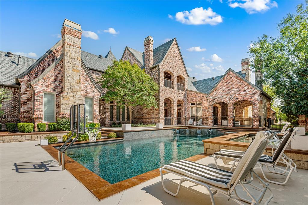 6900 Rockingham Court Colleyville, TX 76034 - Photo 27 of 40 Spacious outdoor living area with a dark-bottom swimming pool, integrated spa, and surrounding stone decking