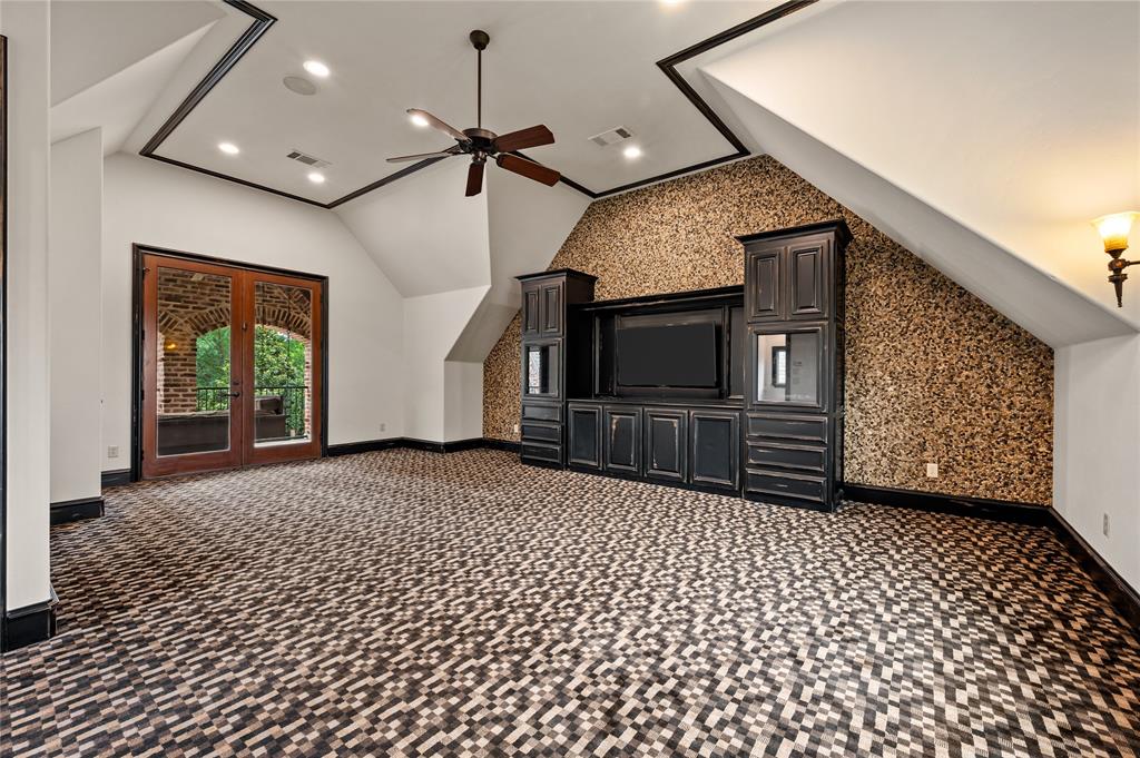 6900 Rockingham Court Colleyville, TX 76034 - Photo 30 of 40 2nd Floor of Guest House ADU features a built-in entertainment center with 2 fish tanks, patterned carpet, ceiling fan, large walk-in closet, and covered balcony with swing