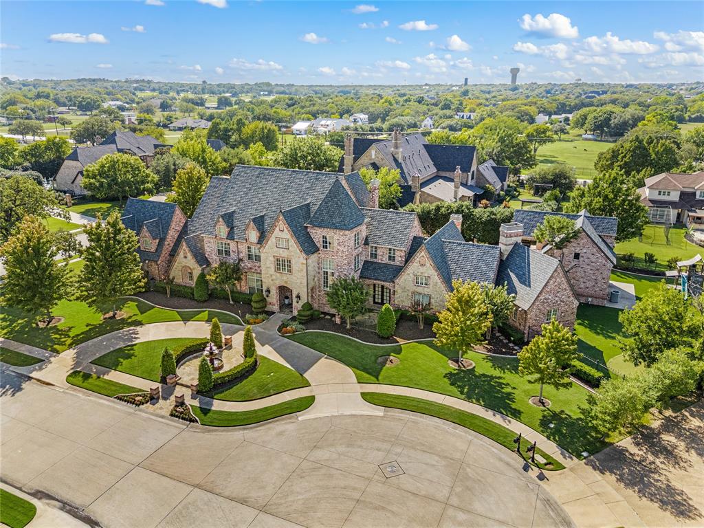 6900 Rockingham Court Colleyville, TX 76034 - Photo 3 of 40 Grand estate featuring a multi-gabled impact resistant roof, stone and brick facade, circular driveway, mature landscaping, and a manicured lawn
