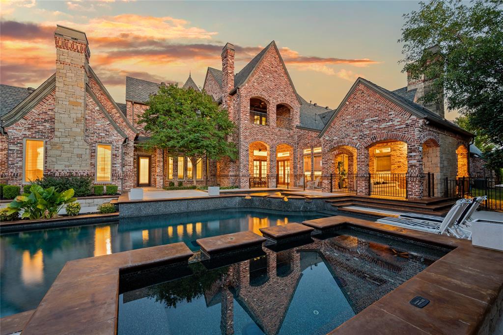 6900 Rockingham Court Colleyville, TX 76034 - Photo 34 of 40 Brick and stone exterior featuring multiple gables and arched openings with 5 balconies and patios overlooking a heated sports pool and spa with Fire and Water features and a separate baby pool