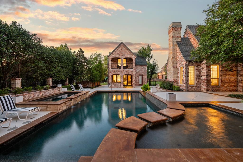 6900 Rockingham Court Colleyville, TX 76034 - Photo 35 of 40 Brick exterior residence featuring a rectangular sports pool with stone surround, an integrated spa, and a separate elevated spa