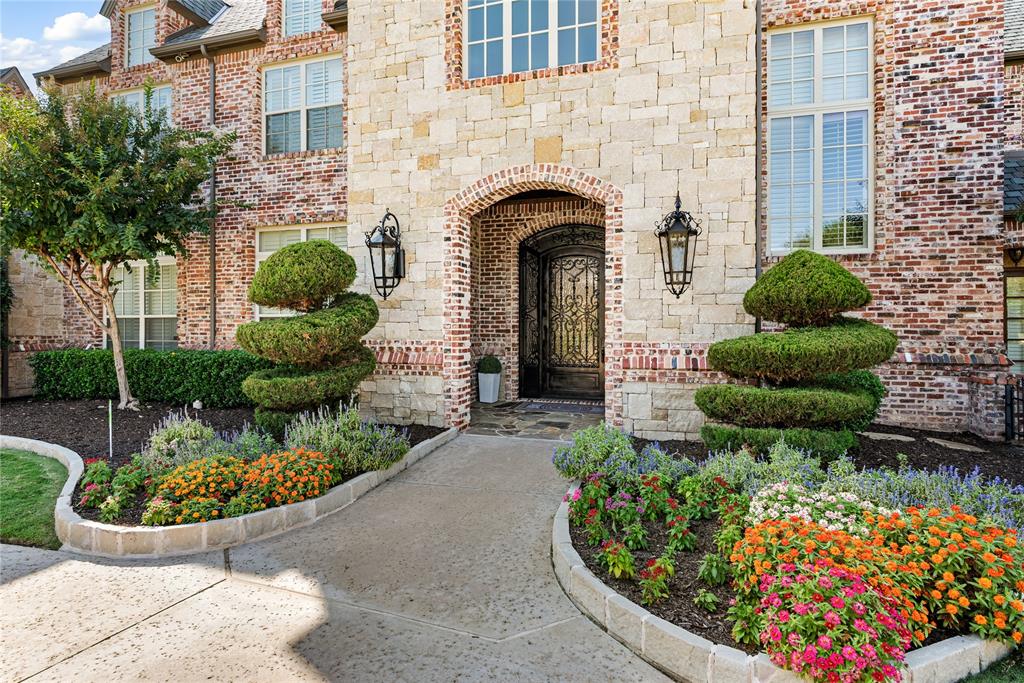 6900 Rockingham Court Colleyville, TX 76034 - Photo 6 of 40 Stone and brick exterior featuring an arched entryway with gas lanterns, covered reception, and an ornate wrought iron door