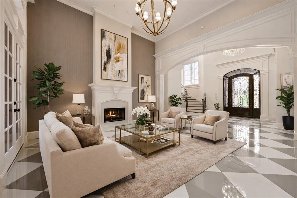 6900 Rockingham Court Colleyville, TX 76034 - Photo 7 of 40 Spacious living area featuring a decorative fireplace with a white mantel, high ceilings, and an arched entry