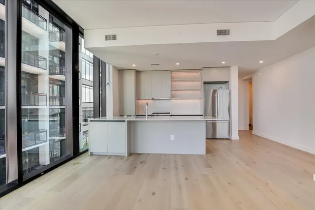 a view of kitchen with stainless steel appliances refrigerator oven and cabinets
