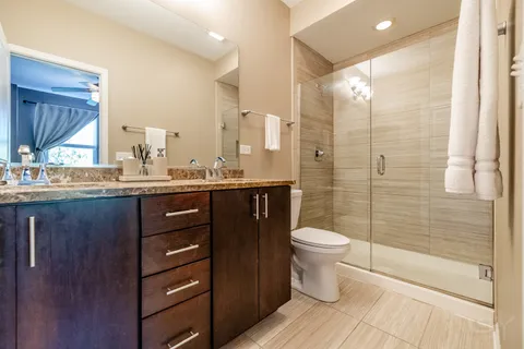 a bathroom with a double vanity sink toilet and shower
