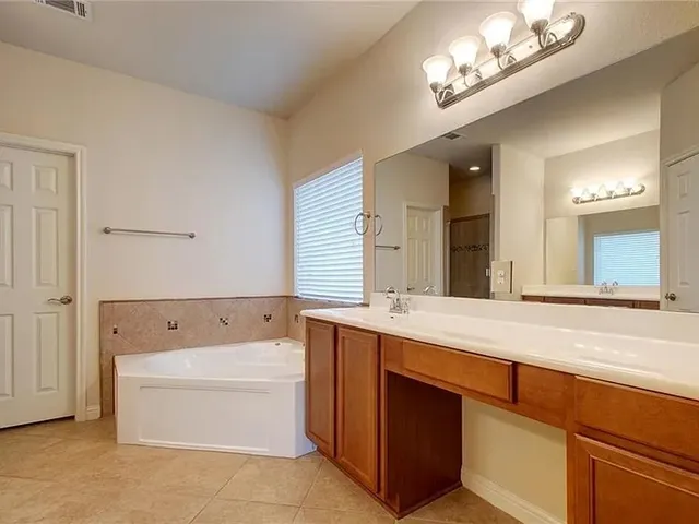 a bathroom with a tub a sink and a mirror