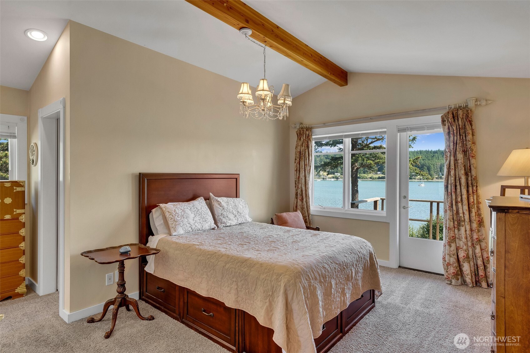 1794 Bayshore Road Lopez Island, WA 98261 - Photo 27 of 39 a bedroom with a large bed and a chandelier