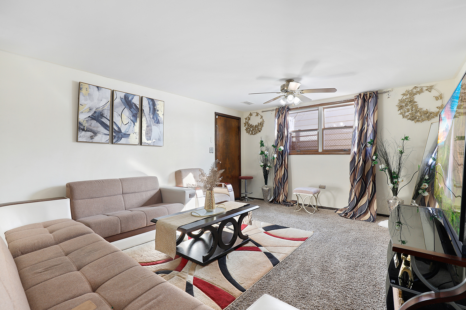 2951 193rd Street Lansing, IL 60438 - Photo 11 of 17 a living room with furniture a flat screen tv and a window