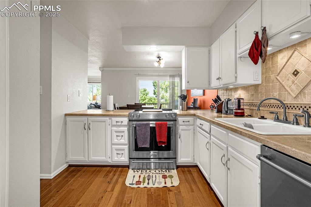 342 Mission Hill Way Colorado Springs, CO 80921 - Photo 12 of 37 a kitchen with kitchen island granite countertop a stove a sink and a microwave