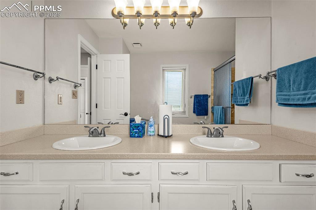 342 Mission Hill Way Colorado Springs, CO 80921 - Photo 31 of 37 a bathroom with double vanity sinks and a mirror