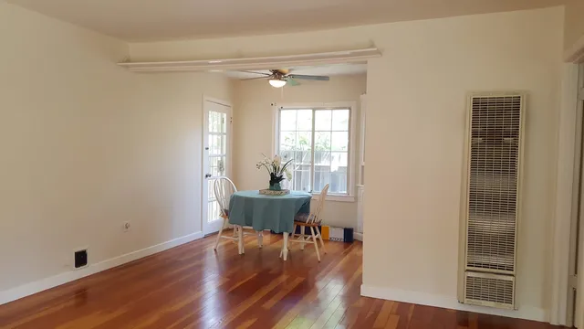 a view of a room that has a glass door and wooden floor