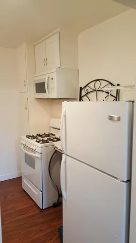 a white refrigerator freezer and a stove sitting inside of a kitchen
