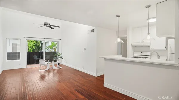 a view of a kitchen with a sink wooden floor and a window