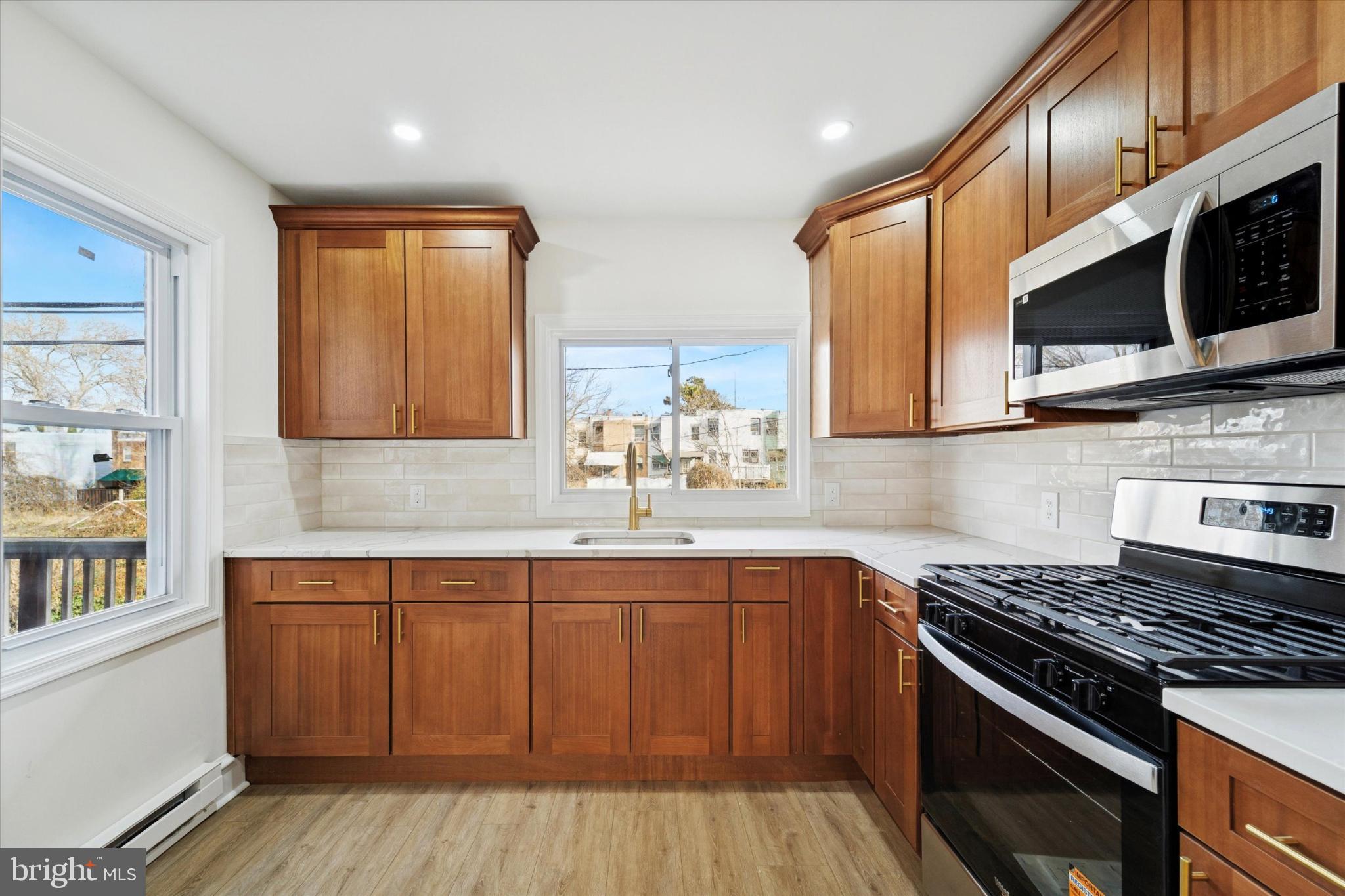 247 Coverly Road Lansdowne, PA 19050 - Photo 22 of 25 a kitchen with stainless steel appliances a sink cabinets and a stove top oven
