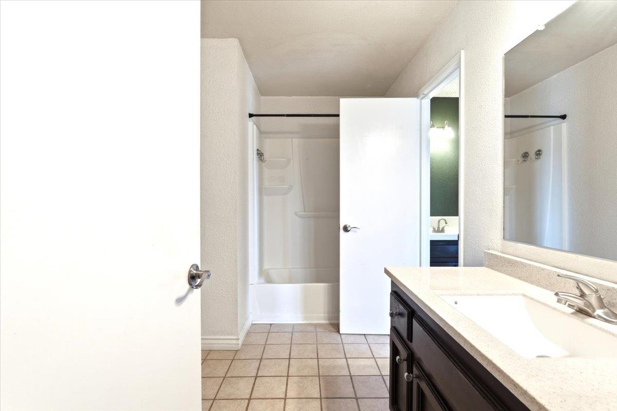 4085 Dale Road, Unit B Modesto, CA 95356 - Photo 18 of 27 a bathroom with a sink a mirror and a bathtub