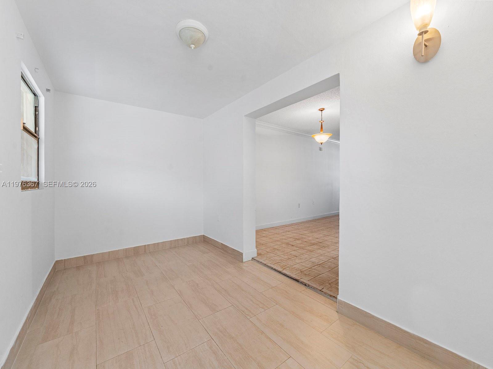 7121 Southwest 102nd Court Miami, FL 33173 - Photo 12 of 33 an empty room with wooden floor and mirror