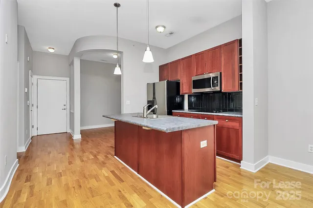 a kitchen with stainless steel appliances granite countertop a sink a refrigerator and a stove