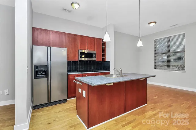 a kitchen with stainless steel appliances granite countertop a sink and a microwave