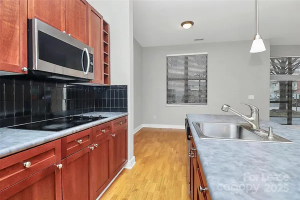 a view of kitchen with stainless steel appliances granite countertop cabinets and a wooden floor