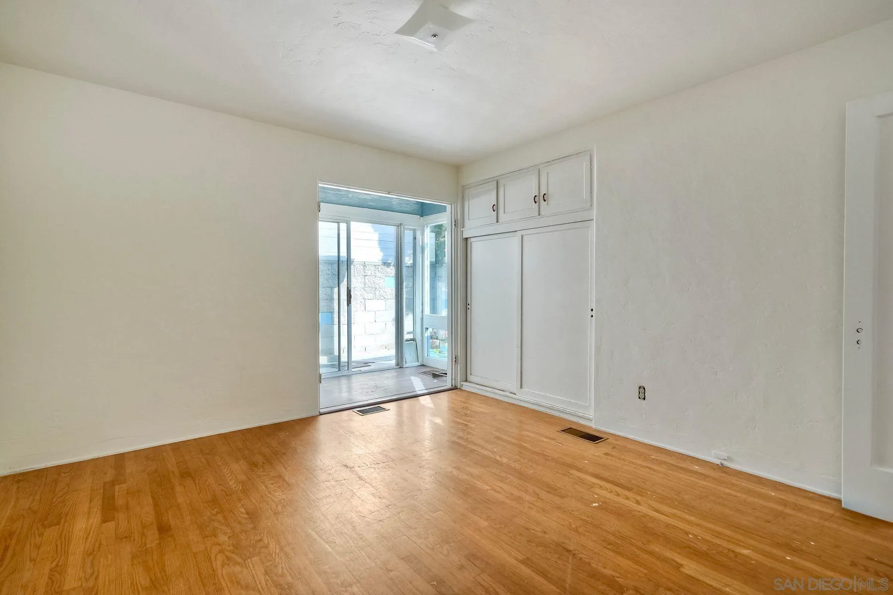 4692 Niagara Avenue San Diego, CA 92107 - Photo 18 of 62 a view of an empty room with wooden floor and a window
