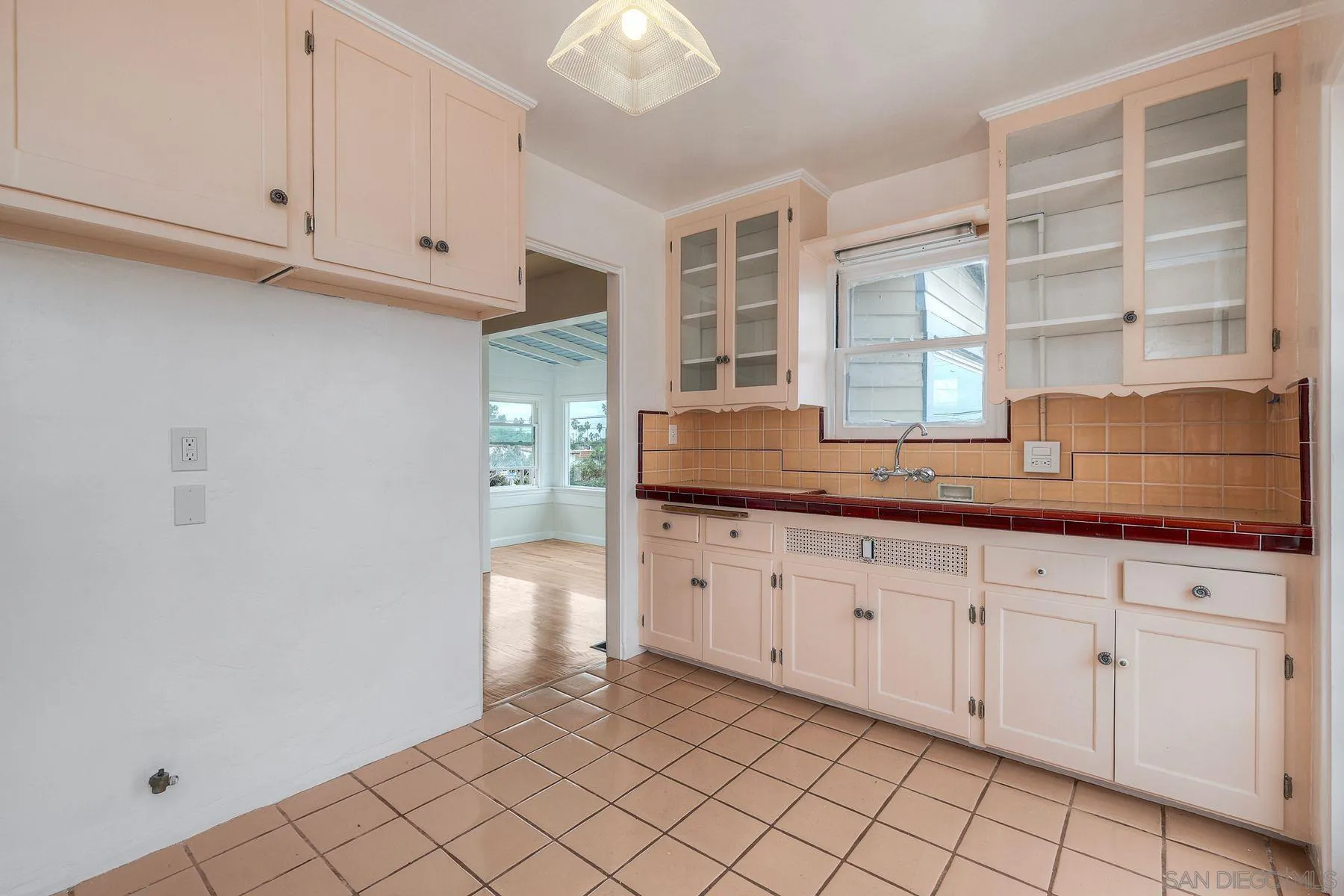 4692 Niagara Avenue San Diego, CA 92107 - Photo 21 of 62 a kitchen with granite countertop white cabinets and window