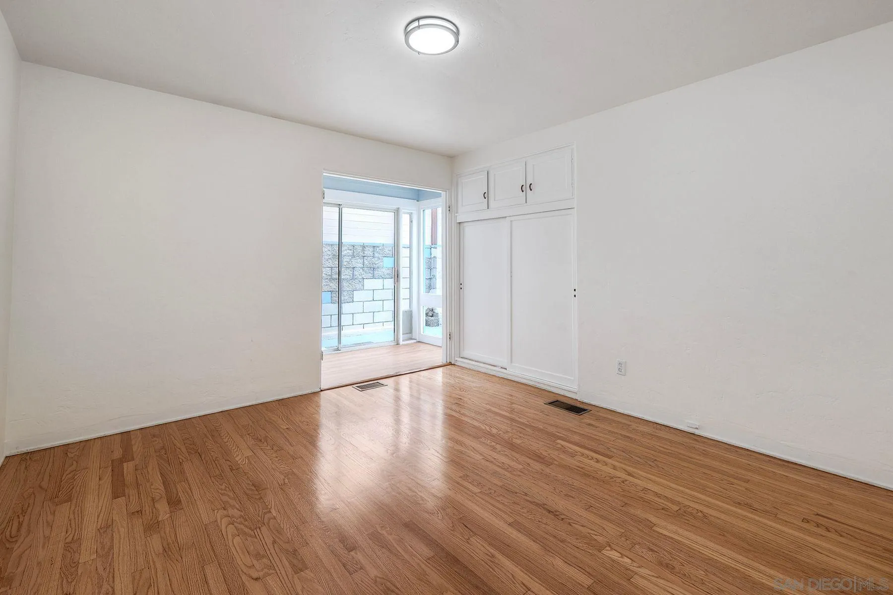 4692 Niagara Avenue San Diego, CA 92107 - Photo 50 of 62 a view of an empty room with wooden floor and a window