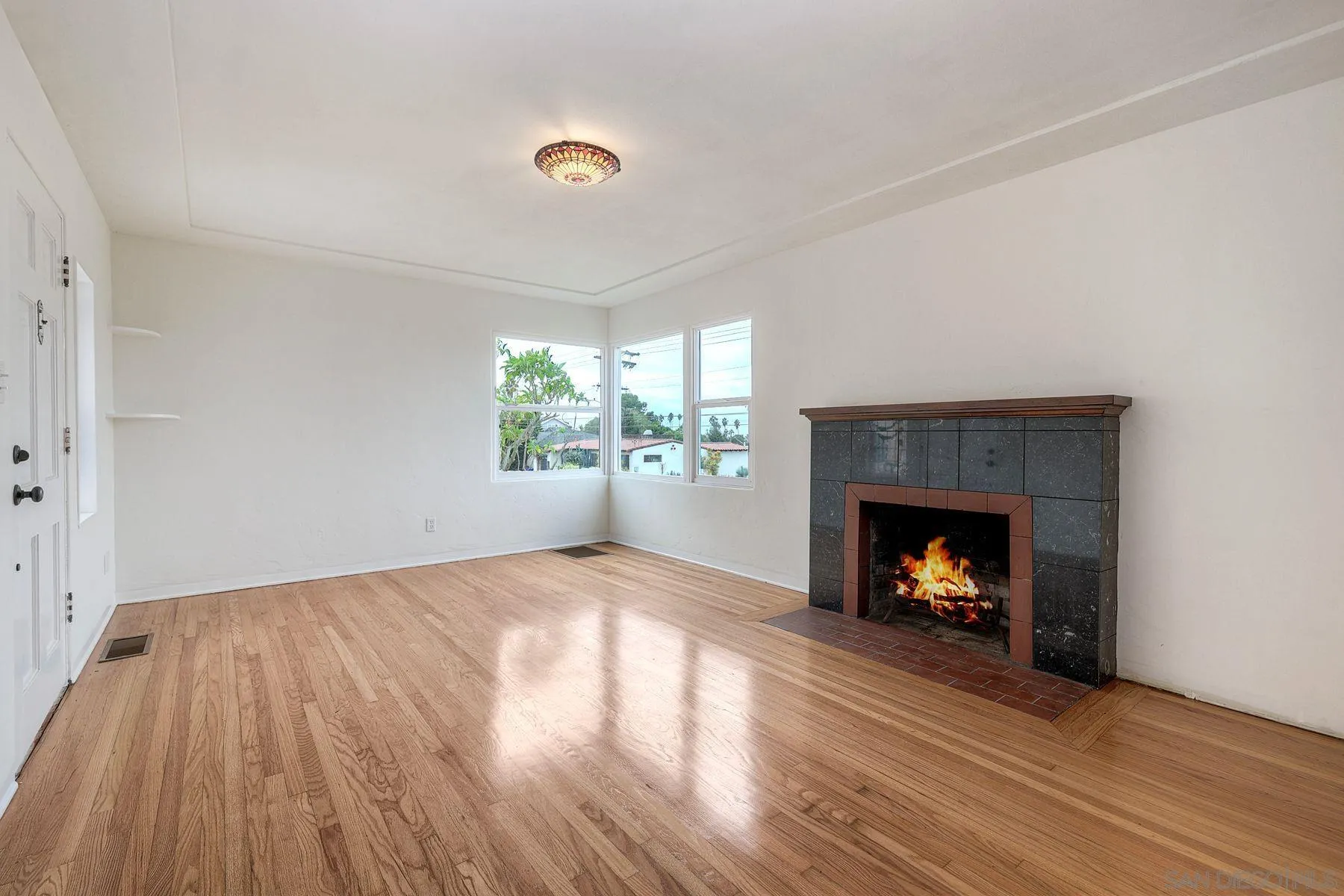 4692 Niagara Avenue San Diego, CA 92107 - Photo 10 of 62 a view of an empty room with a fireplace and window
