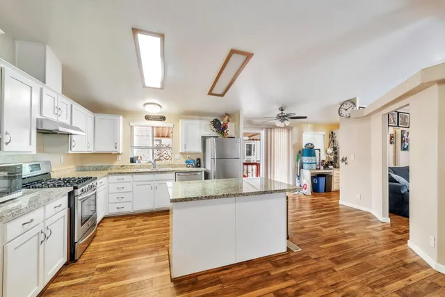 a large kitchen with cabinets and wooden floor