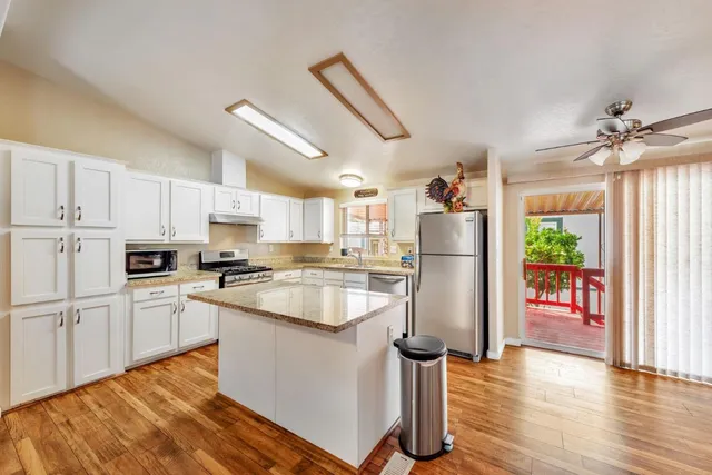 a kitchen with white cabinets and refrigerator