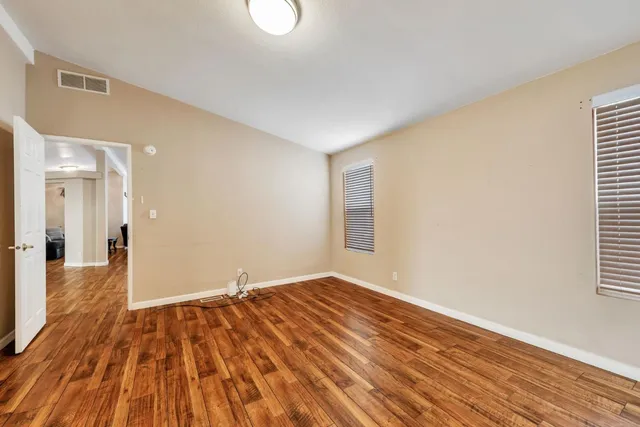 a view of a room with wooden floor and a window
