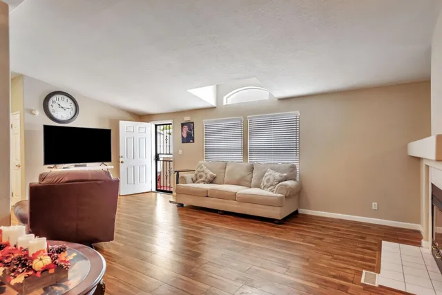 a living room with furniture wooden floor and a flat screen tv