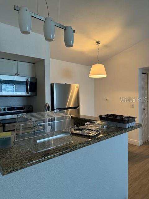 5160 Conroy Road, Unit 32 Orlando, FL 32811 - Photo 2 of 4 a kitchen with stainless steel appliances granite countertop a sink a stove and a microwave