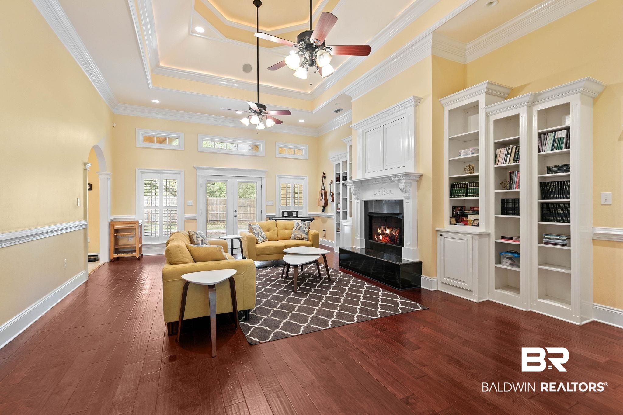 3668 Claridge Road North Mobile, AL 36608 - Photo 24 of 100 Living area with ceiling fan, dark wood-style flooring, a tray ceiling, a fireplace, and crown molding