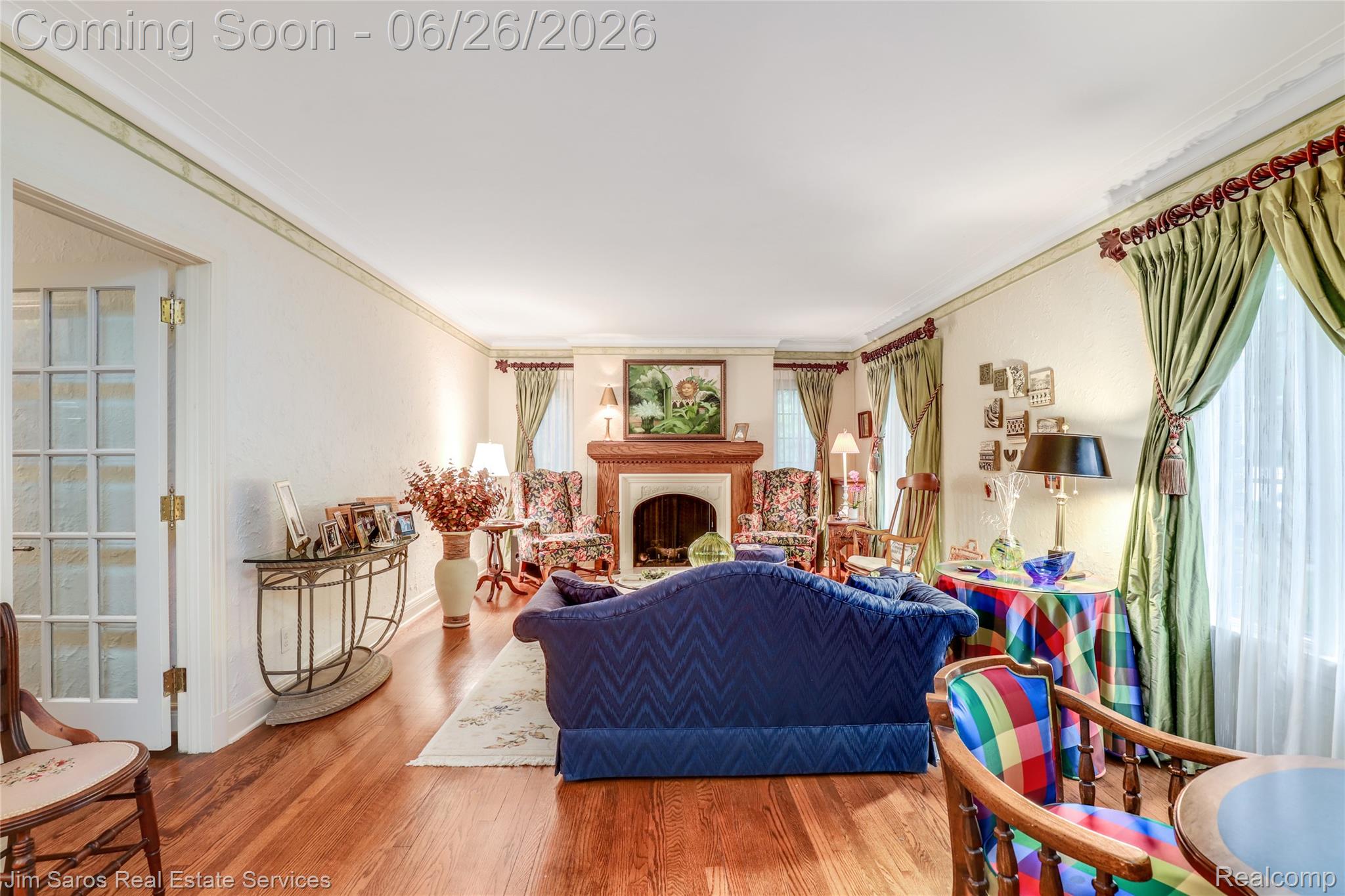 764 Harcourt Road Grosse Pointe, MI 48230 - Photo 4 of 42 Living area featuring hardwood flooring, a central fireplace with a substantial mantel, white crown molding, and a French door with multiple glass panes